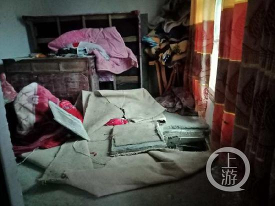  ▲犯罪嫌疑人龙某和卧室里的地下室入口。摄影/上游新闻记者 牛泰