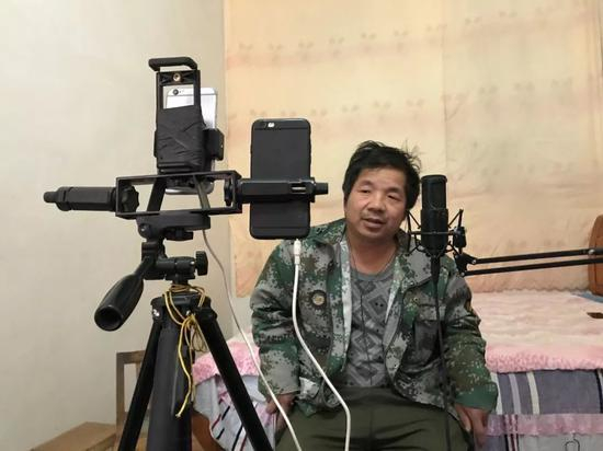 窦师傅直播时，一部手机用来拍摄，另一部用来播放音乐。新京报记者祖一飞 摄