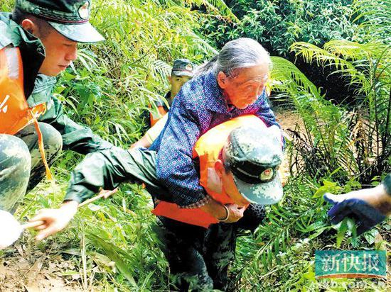 13日，武警河源支队官兵在山路上转移群众。新华社发