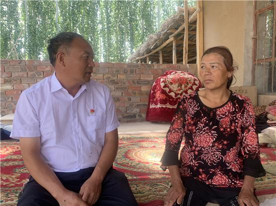 黄英杰（左）走访村民。人民网 宋晨摄