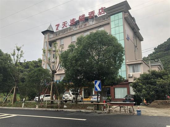　　在租客曾入住的连锁酒店门口，马路边最右一张桌就是子欣爷爷奶奶的水果摊位。 顾杰 摄