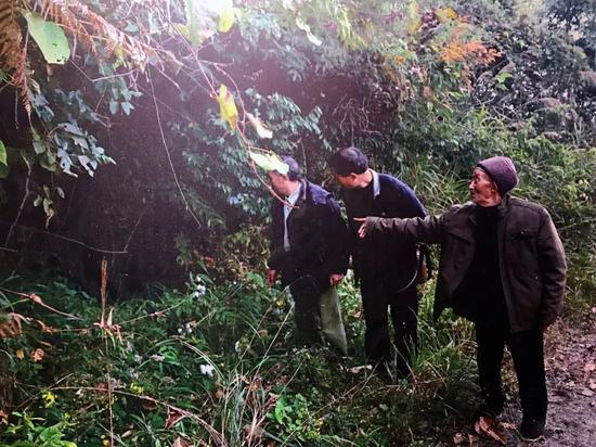  游朝佑老人介绍当年负伤红军战士藏身的山洞（资料图）