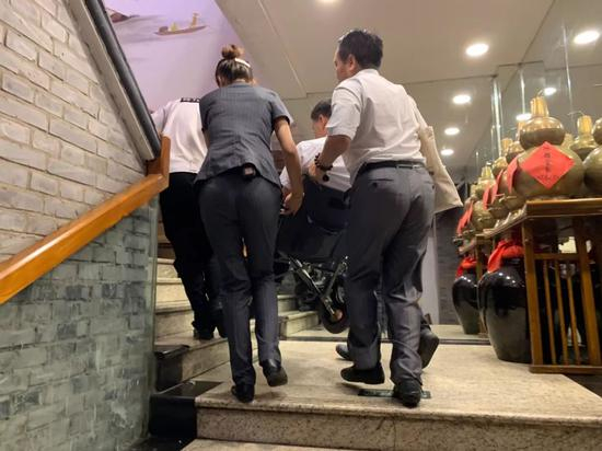 　　7月15日，北京市东城区的一家饭馆，由于没有设置无障碍直梯，只能用人力将残障顾客抬上楼。新京报记者周小琪&nbsp;摄