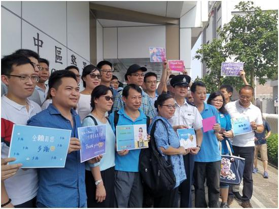 在香港中区警署门前，市民与警察合影。