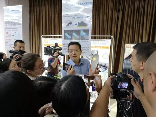 （图为晋江石墨烯研究院首席专家许志展示研制的石墨烯鞋垫）