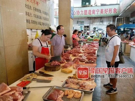 ▲8月31日上午，一市民在南宁麻村市场购买猪肉。