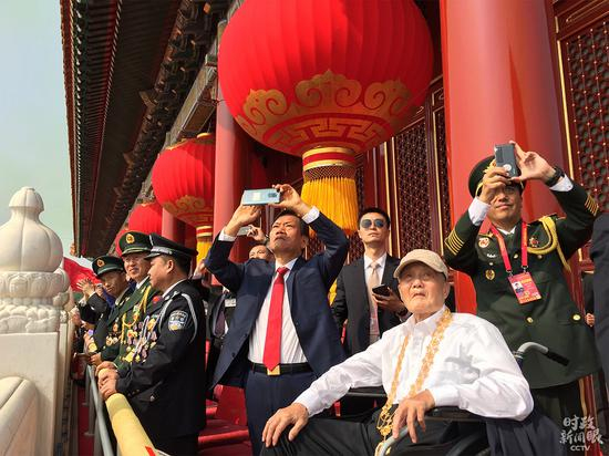 △“共和国勋章”获得者张富清在城楼上观看阅兵式。（央视记者郭鸿拍摄）