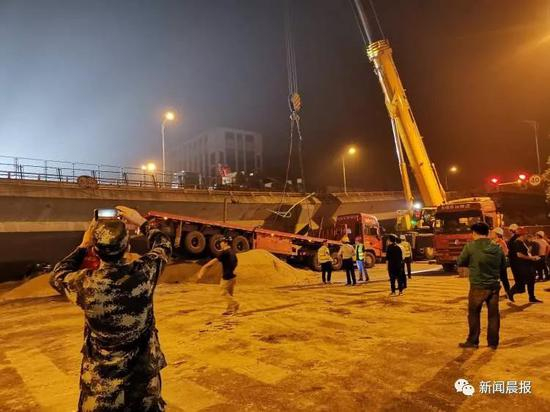  被吊下的卡车落在运来的黄沙上。摄影/宋奇波