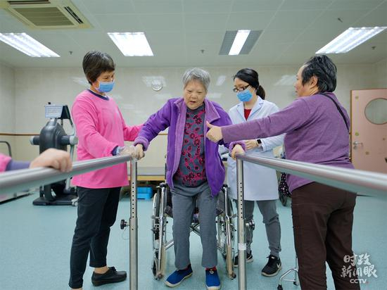  △澳门街坊总会颐骏中心成立于2007年，是一家专业的老年人服务机构。这是老人正在义工的帮助下做康复锻炼。（央视记者彭柏闳拍摄）