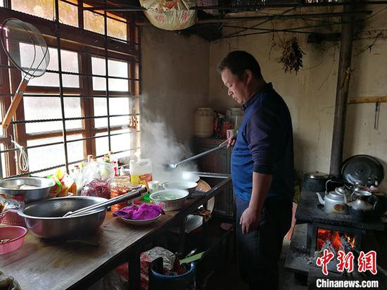 图为独龙族农家乐老板王战荣给客人备菜。 中新社记者 胡远航 摄