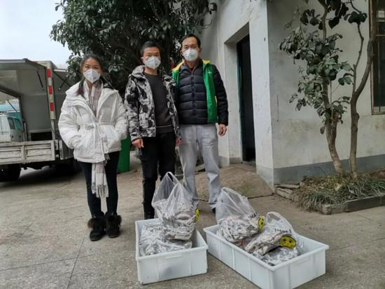刘浩（中）将冻鲫鱼送到武汉动物园。| 图源@花落成蚀