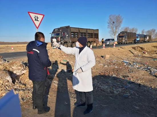  青山村村医正在给接羊群回家的司机测体温。