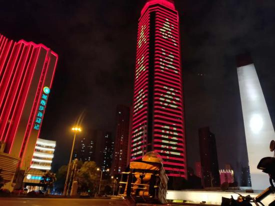  经过一座亮着“武汉必胜”的大楼时，郭峰停车拍了张照。受访者供图