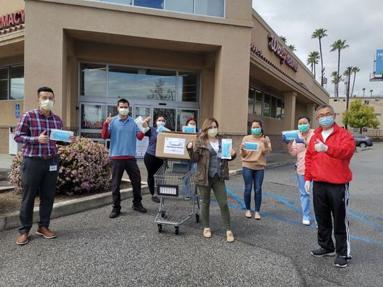  4月7日，在美国洛杉矶县天普市，美国南加州华人联合总会代表向当地一家药店捐赠口罩时合影。（新华社发，美国南加州华人联合总会供图）