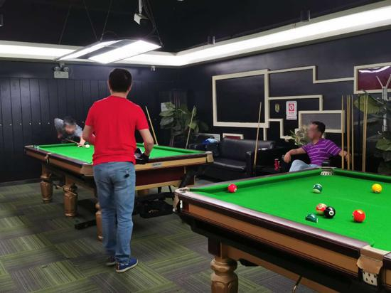  广渠门内地铁站附近的台球厅，所有的台球桌都已满员。