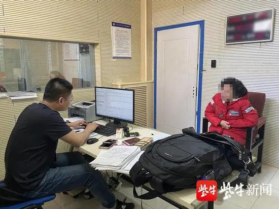  图为民警对嫌疑人李某进行讯问。