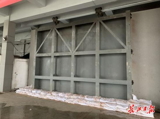 迎水面，钢闸门底部设置有沙袋，进一步防止江水渗漏。 记者乔驰 摄