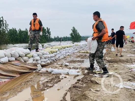  7月13日，江西九江市江洲镇，解放军和武警官兵在抗洪一线修筑防洪堤坝。&nbsp;/记者 时婷婷