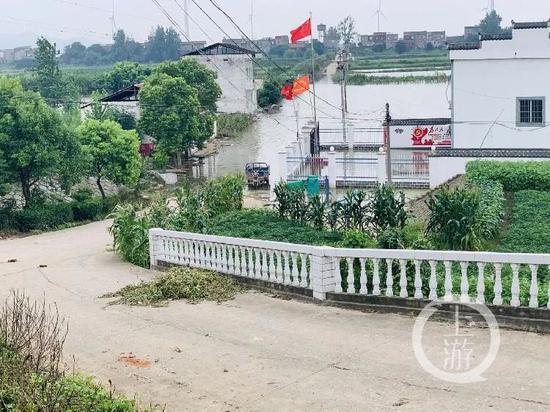  7月13日，江西九江市江洲镇，低洼地带的水泥路已被江水淹没。/记者 时婷婷