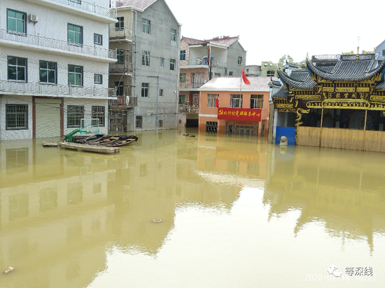 　　水中的昌洲乡北兴村党群服务中心。门前操场上的篮球架前，聚集了5艘船和一个由几块木板相拼而成的漂浮物。