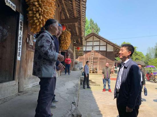 孙志明（右一）走访贫困户