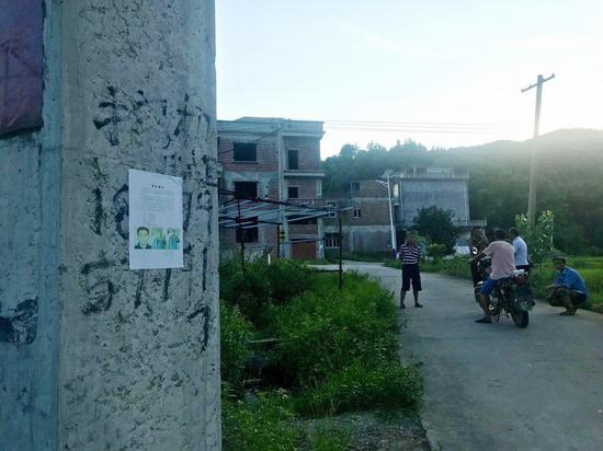 在曾春亮老家厚坊村，张贴着他的悬赏通告。村民聚在一起讨论凶案。&nbsp; 本文图片&nbsp;澎湃新闻记者 俞骄