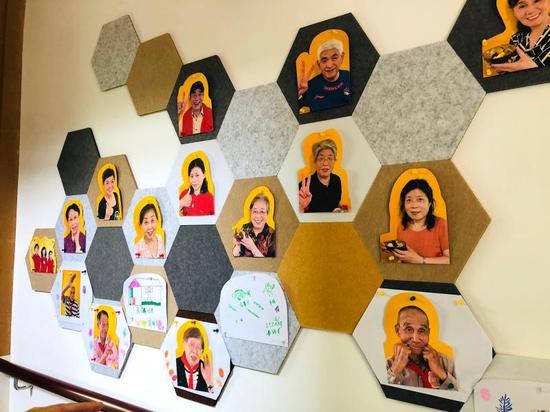 乐山邻里汇，墙上贴满了居民的笑脸，还有老爷爷挥手“卖萌”。  舒抒 摄于今年10月