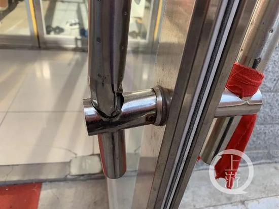 被害人吕某强行破门闯入，造成足疗店大门损坏，修好后仍可看出变形严重。/记者&nbsp; 张莹