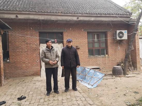 王哲峰和父亲在自家的院子里。新京报记者 李桂 摄