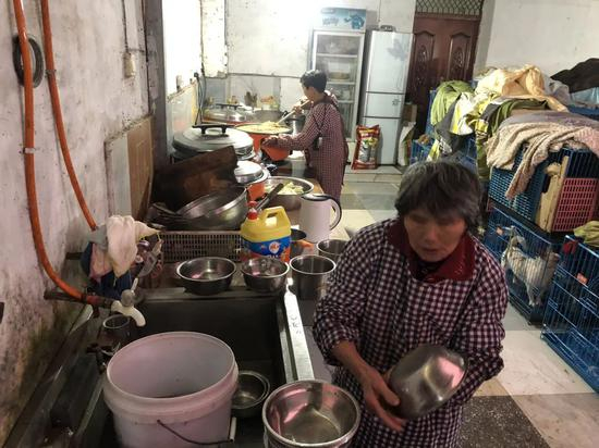 ▲文军红和工人给狗准备吃的，它们一天要吃500斤米。新京报记者&nbsp;王翀鹏程 摄&nbsp;