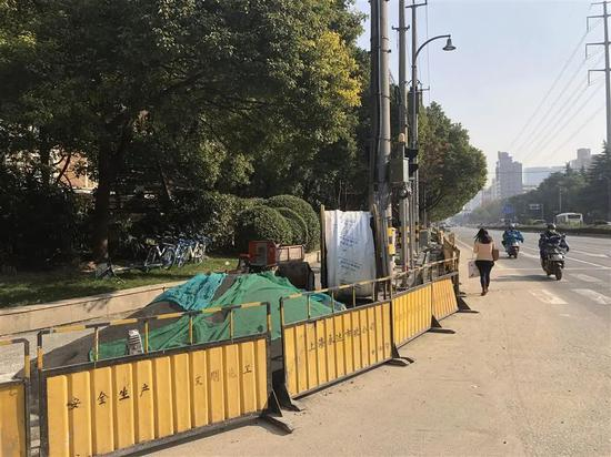 △天山路天山河畔小区门口的人行道，黄色施工围栏圈了个严实，行人只能从非机动道绕行。