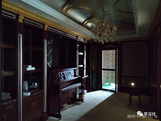 “1号套房”的起居室。出于私密性考虑，阳台上的落地窗帘常年处于关闭状态，该阳台未遮严实的缝隙透进的光线经过灰色纱窗门射进黑暗的起居室中，明亮与黑暗之处形成强烈反差，物件上反射出冷冷的光，透出一丝恐怖气氛。图中铺有绿色塑料假草坪的阳台，是敲空墙壁后，用钢架在外硬生生搭建出的一个阳台。&nbsp; &nbsp; &nbsp; 《等深线》记者&nbsp;程维 摄