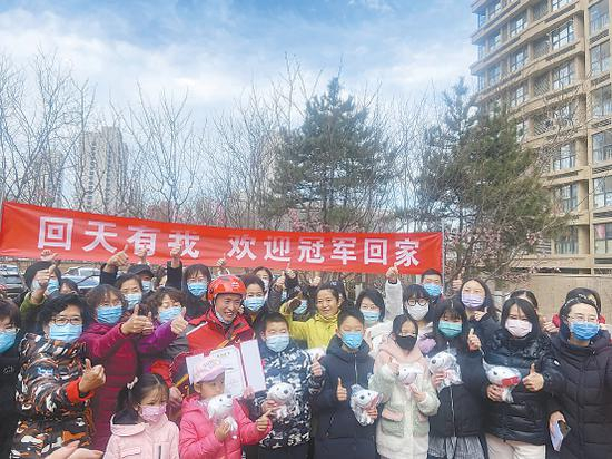 在欢迎仪式上，居民们簇拥在王冠军身边，合影留念。