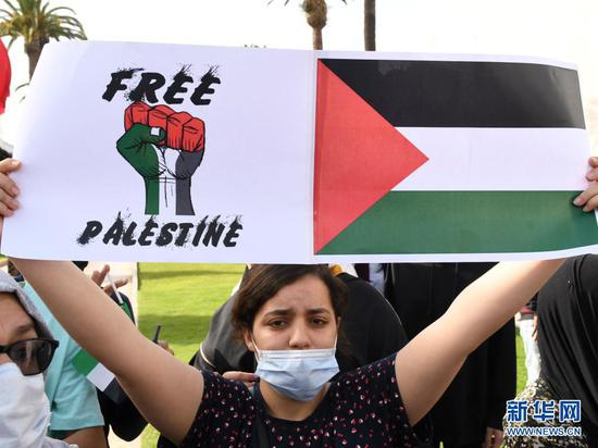 2021年5月15日，一名女子在摩洛哥首都拉巴特参加抗议示威活动，声援巴勒斯坦民众。 新华社 图