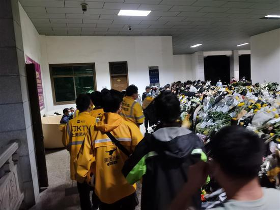 送别队伍中，外卖小哥们为袁隆平献上稻穗。