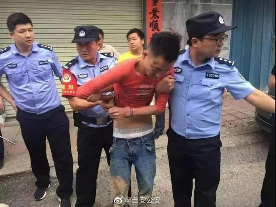 9月9日上午，嫌疑人谢某被2名警方左右羁押，面向马路指认案发现场。