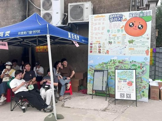 图为莫氏鸡煲“候鸡亭”，游客们在等待之余，了解陈村镇文旅路线。兰航宇 摄