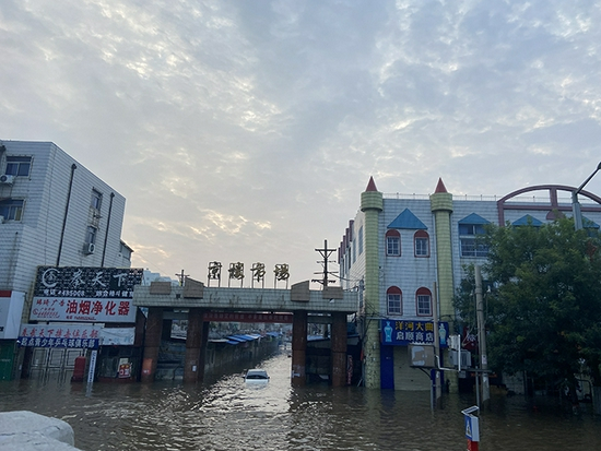 卫辉市区水深处超1米，远处一辆轿车车顶即将被淹没。