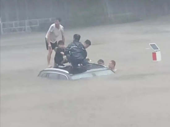  小男孩已经被救到了车顶。视频截图
