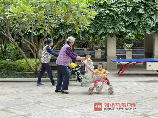 ▲10月21日，南宁市天气降温，出行市民给孩子们换上厚衣物。南国早报记者 邹财麟摄