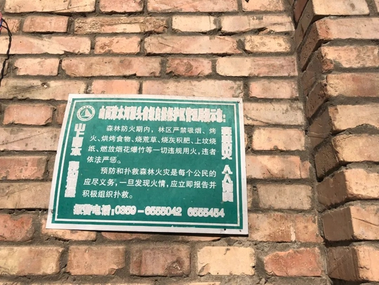  里册峪村内，村民家墙上贴的森林防火警示牌。冬季干燥，是森林防火的重要时期。