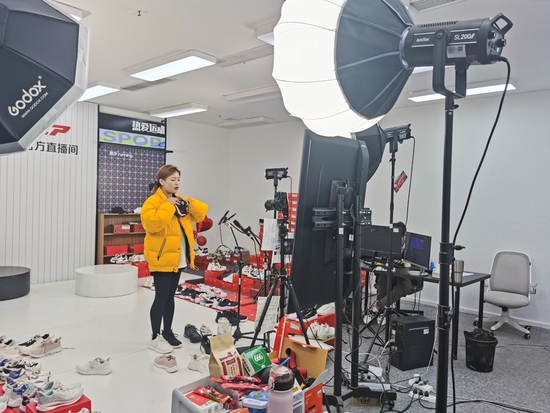 某运动品牌直播间内，主播正在镜头前试穿运动鞋。 巩持平 摄