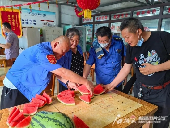 6月11日，乌鲁木齐市紫金方城公交车停车场，公交车驾驶员们跑完车吃西瓜解暑。石榴云/新疆日报记者 索蓉芝摄