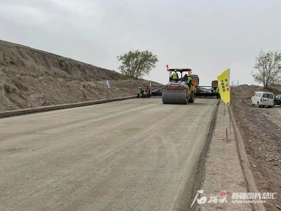 2022年5月25日，昌吉回族自治州西部南山伴行公路（二期），工人们正在铺设路基。王兵摄
