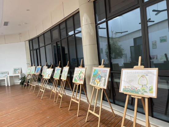 秦岭植物园科普教育馆活动中心摆放着学生们以生态保护为主题的绘画作品。（王爽宇 摄）