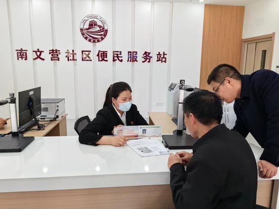  5月10日，雄安新区容东片区南文营社区居民段峰（右二）在便民服务站咨询补办社保卡事宜。新华社记者 曹国厂 摄