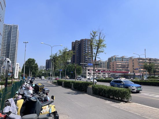  7月9日上午，济南市一处居民区附近停着许多外卖车辆，路上行人稀少。当日济南市气象台发布了高温橙色预警信号。 新华社记者叶婧 摄