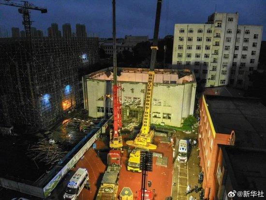 7月23日，消防救援人员在现场搜救受困人员，体育馆屋顶全部坍塌。@新华社 图