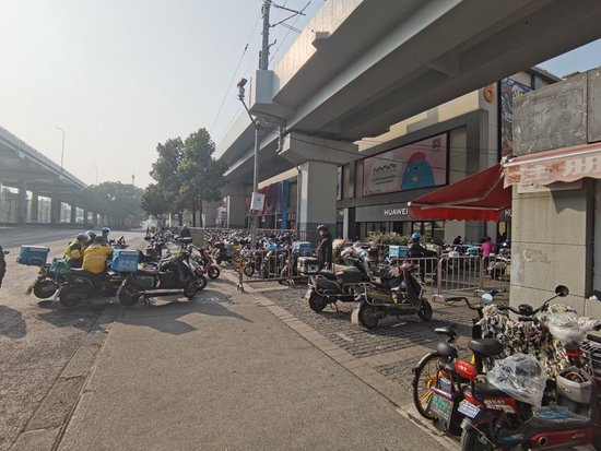  △“宝山新业坊”商圈外卖业务集中，图为骑手们正在等单。