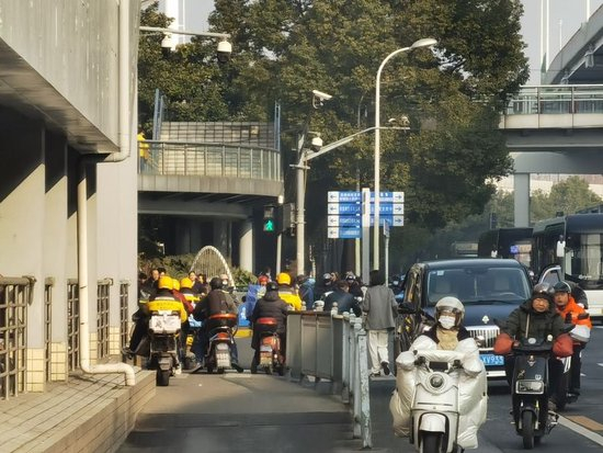 △逸仙路殷高西路路口南北向红灯时，等灯的逆行骑手能排成一排。